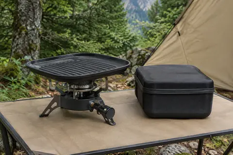Réchaud de camping à gaz avec plaque de grill antiadhésive et étui rigide dans un sous-bois