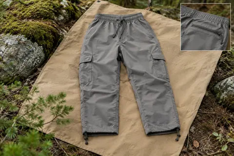 Pantalon de randonnée femme 3/4 avec poches cargo, posé sur une toile dans un sous-bois